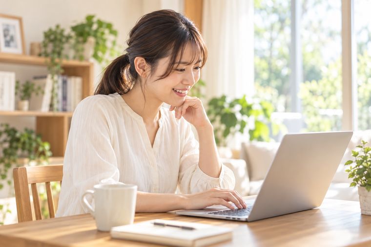 ノートパソコンに向かってほほえむ女性
